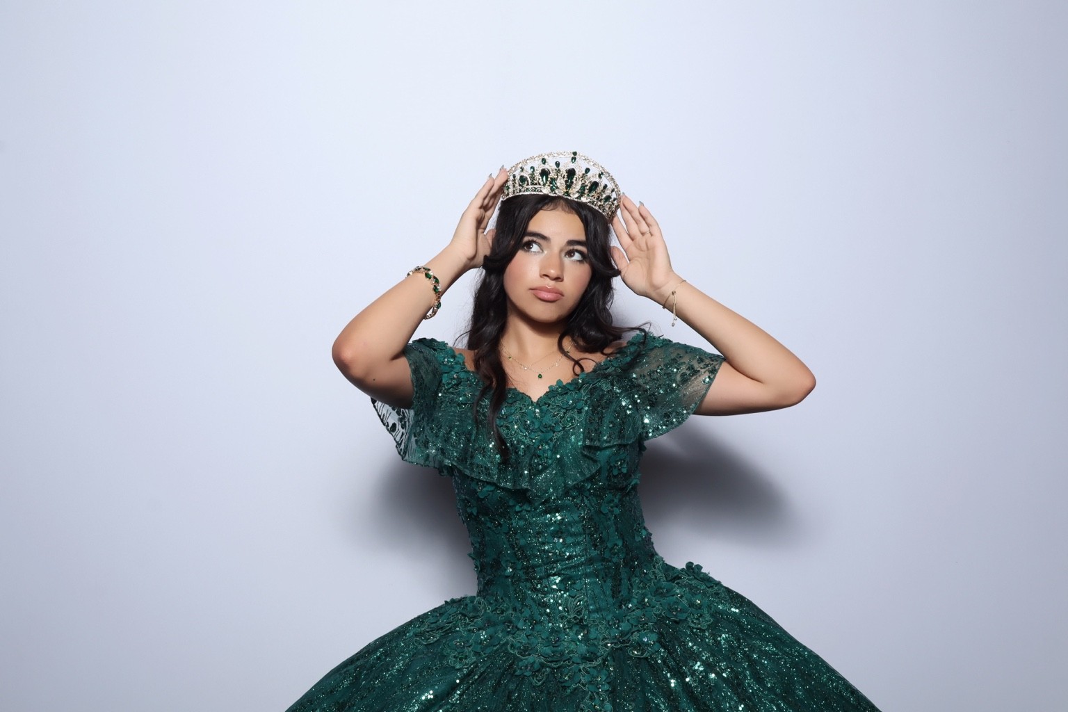 Quinceañera guest of honor in an elegant green gown and tiara
