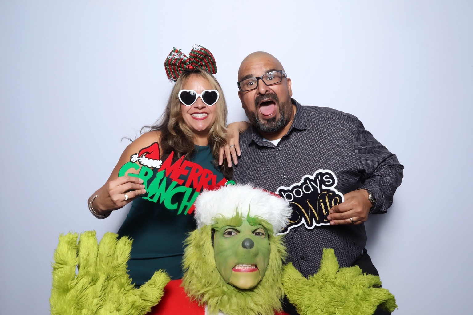 Guests posing with festive props and a Grinch costume