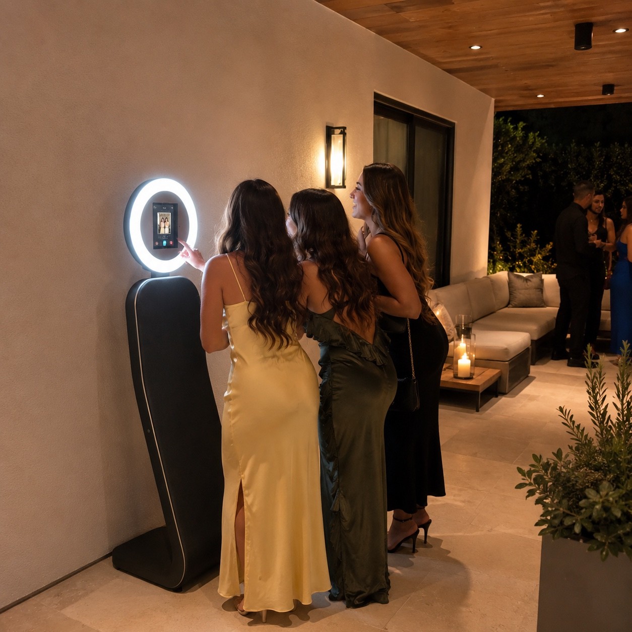 Three guests gathered around the Tinseltown Selfie Studio booth